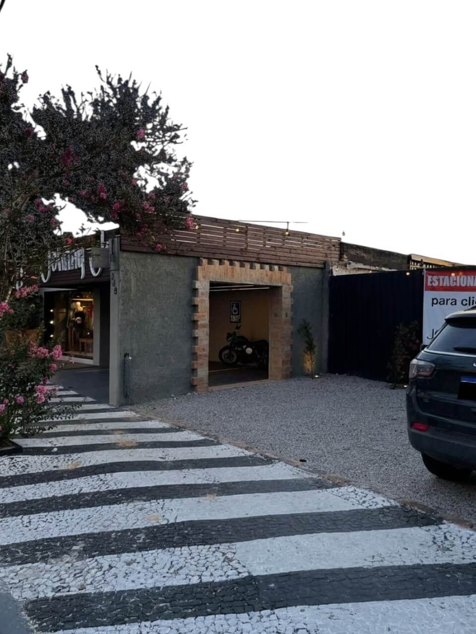 Entrada e estacionamento da loja com faixa de pedestres em destaque